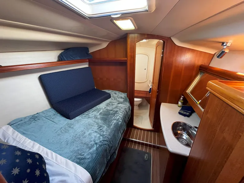 Slide: The Image of Cozy cabin interior of 2005 Hunter 41 sailboat with bed, sink, and wooden finish. - 43