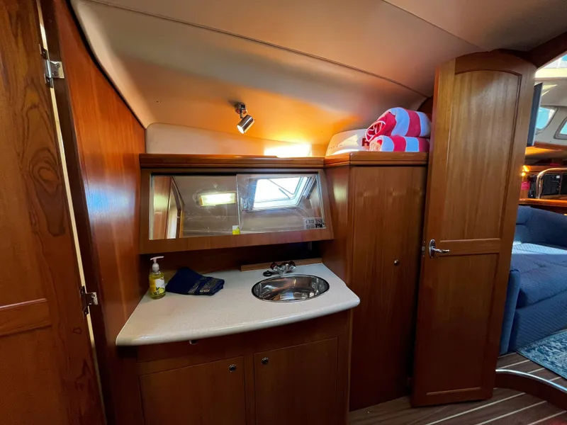 Slide: The Image of 2005 Hunter 41 yacht interior with wooden cabinetry, sink, and mirror. - 44