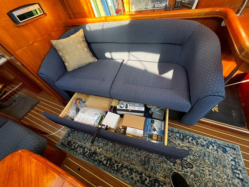 Slide: The Image of Blue sofa with storage drawer open, inside a 2005 Hunter 41 yacht cabin. - 49