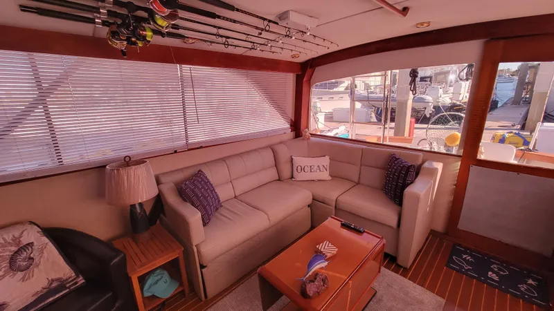 Slide: The Image of Cozy interior of 1988 Ocean Yachts 38 Super Sports with plush seating and fishing rods. - 13