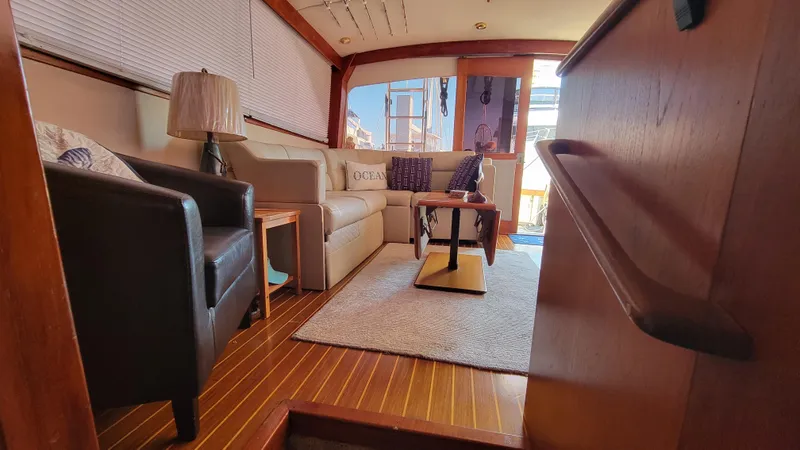 Slide: The Image of Interior of 1988 Ocean Yachts 38 Super Sports, featuring cozy seating and elegant wood finishes. - 14