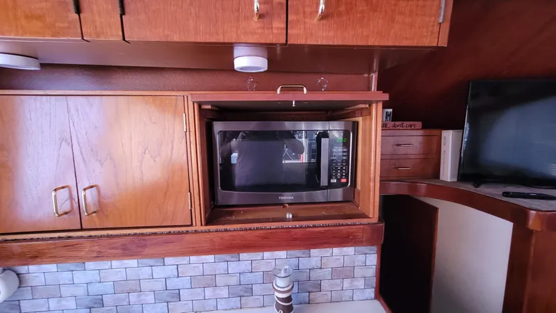 Slide: The Image of Microwave in 1988 Ocean Yachts 38 Super Sports kitchen with wood cabinetry and tiled backsplash. - 15