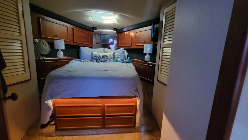 Slide: The Image of Cozy bedroom interior of 1988 Ocean Yachts 38 Super Sports with wooden cabinets and soft lighting. - 16