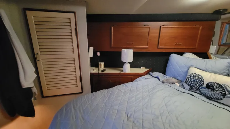 Slide: The Image of Cozy bedroom in 1988 Ocean Yachts 38 Super Sports with blue bedding and wooden cabinets. - 18