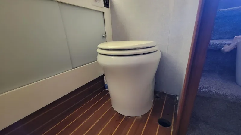 Slide: The Image of 1988 Ocean Yachts 38 Super Sports bathroom with white toilet and wooden floor. - 27
