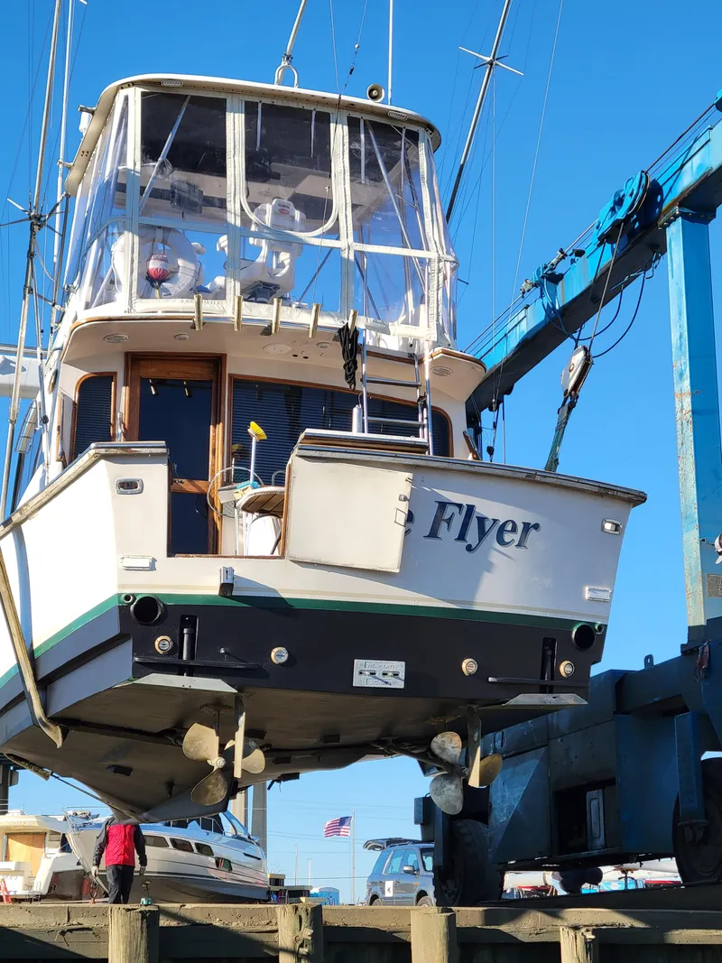 Slide: The Image of 1988 Ocean Yachts 38 Super Sports boat named "Flyer" on a lift at a marina. - 47