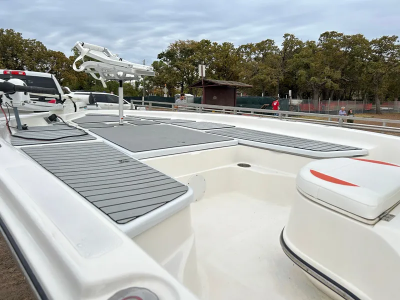 Slide: The Image of 2013 Epic 22 SC boat with sleek deck design and seating, parked outdoors. - 15