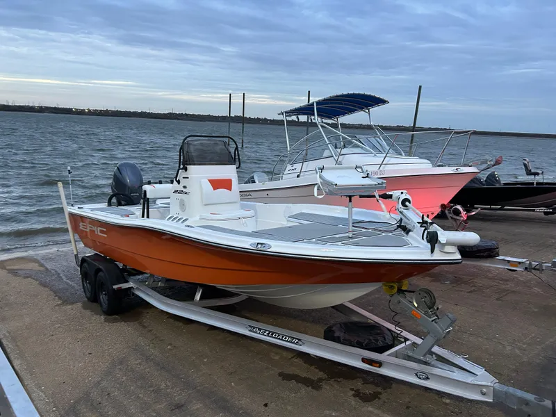Slide: The Image of 2013 Epic 22 SC boat on trailer by the water, with other boats in the background. - 18