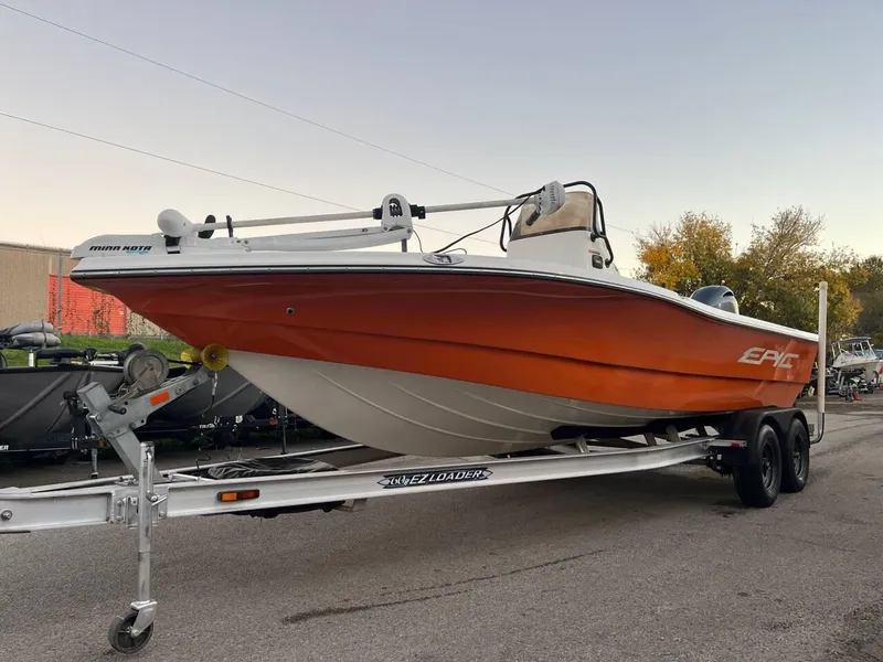 Slide: The Image of 2013 Epic 22 SC boat on trailer, orange hull, parked outdoors. - 2
