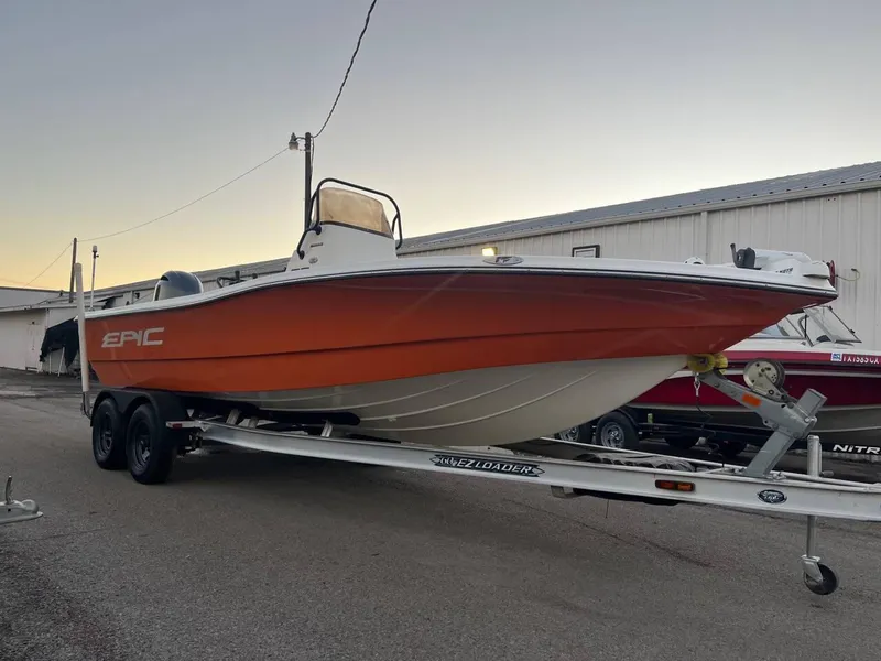 Slide: The Image of 2013 Epic 22 SC boat on trailer, orange hull, parked outdoors. - 21