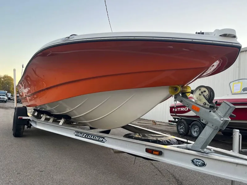 Slide: The Image of 2013 Epic 22 SC boat on trailer, orange hull, parked outdoors. - 3