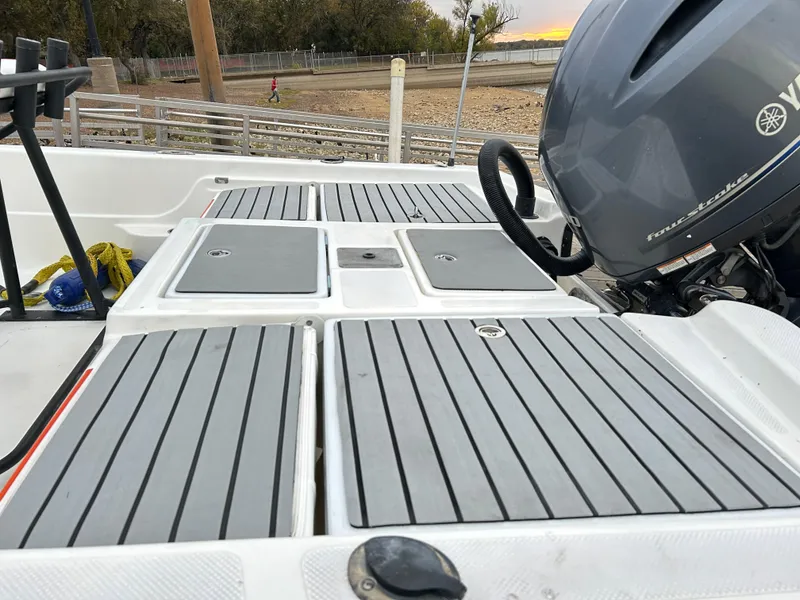 Slide: The Image of Epic 22 SC 2013 boat deck with Yamaha outboard motor, docked near shore. - 40