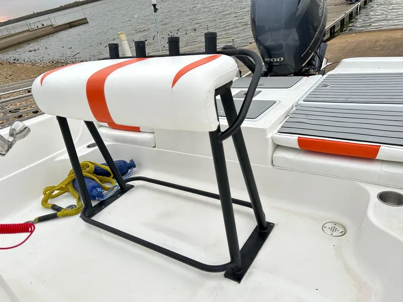 Slide: The Image of 2013 Epic 22 SC boat interior with seating and motor, docked by the water. - 44