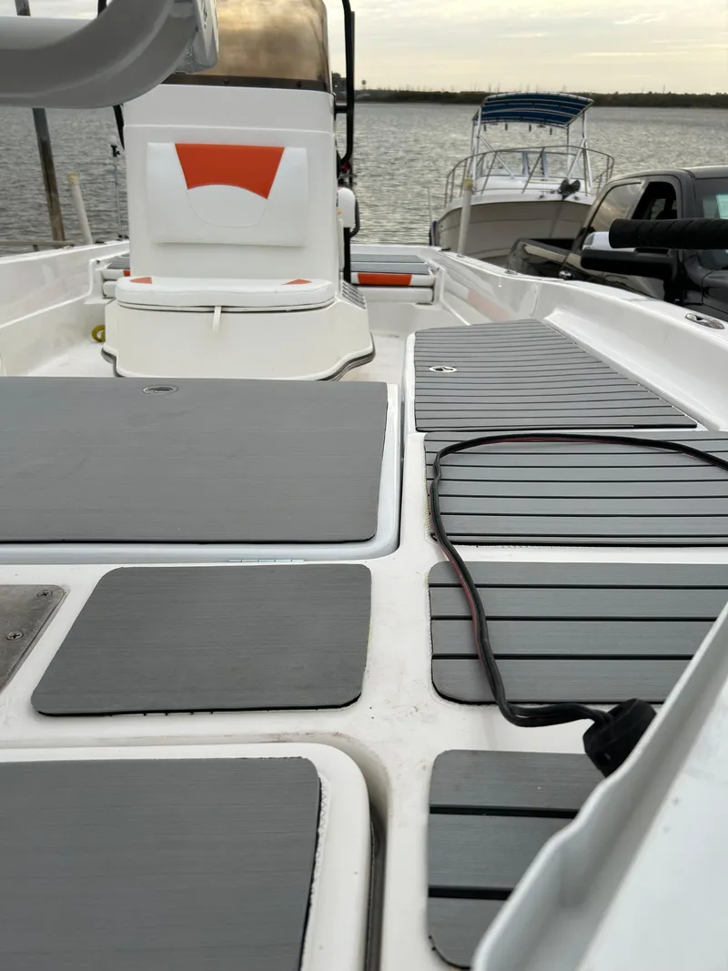 Slide: The Image of 2013 Epic 22 SC boat interior with gray deck, docked by the water. - 49