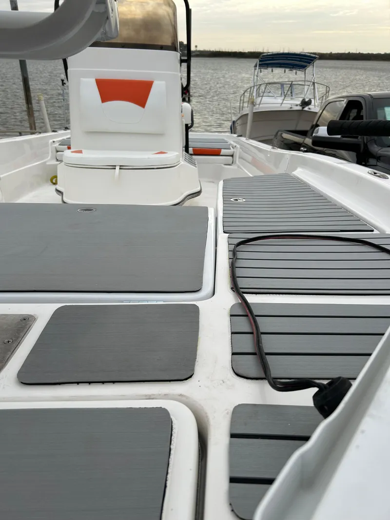 Slide: The Image of 2013 Epic 22 SC boat interior with gray deck, docked by the water. - 50