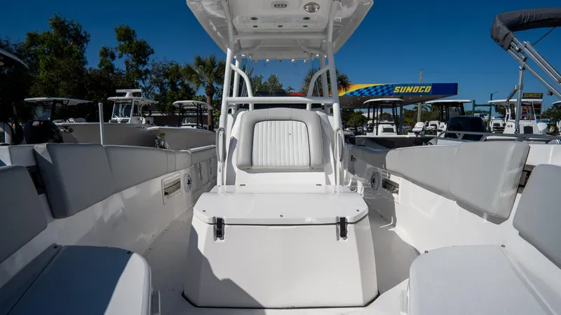 Slide: The Image of 2024 Sea Fox 268 Commander boat interior with seating and console, under clear blue sky. - 14