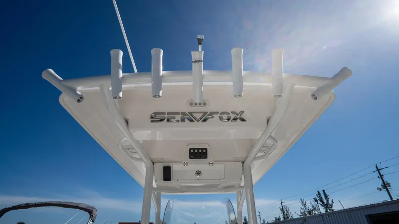 Slide: The Image of 2024 Sea Fox 268 Commander boat top view with rod holders against blue sky. - 33