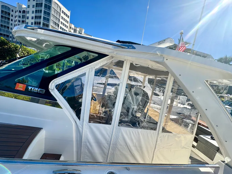 Slide: The Image of 2018 Tiara Yachts 38 LS docked near modern buildings under clear blue sky. - 19