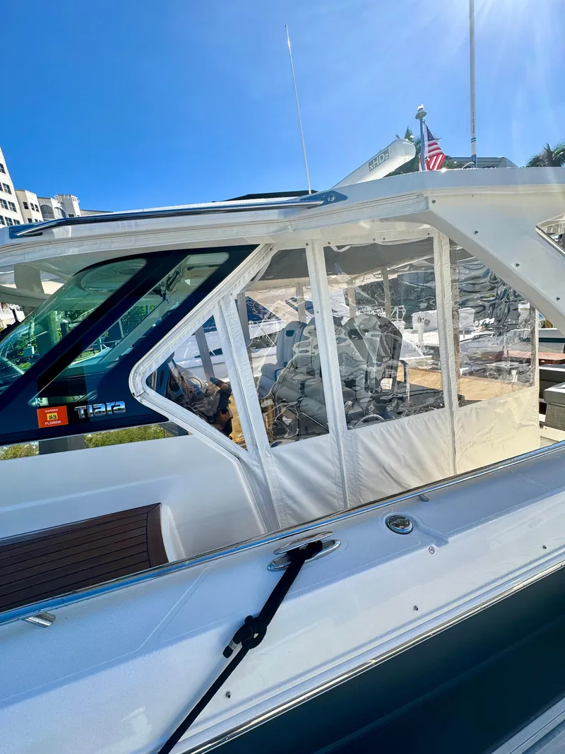Slide: The Image of 2018 Tiara Yachts 38 LS with enclosed cockpit, docked under clear blue sky. - 20