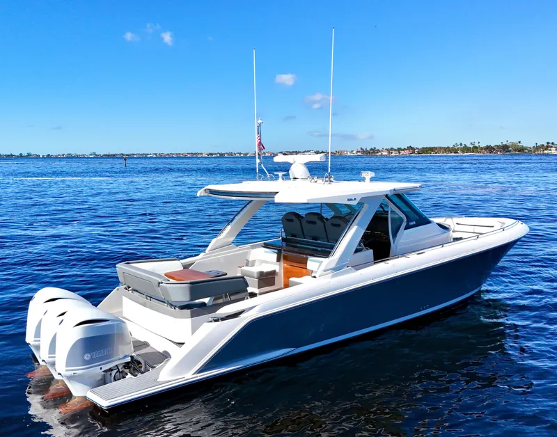 Slide: The Image of 2018 Tiara Yachts 38 LS on calm blue water, showcasing sleek design and triple engines. - 29