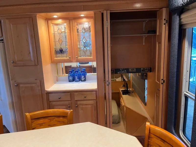 Slide: The Image of Interior of a 2001 Sharpe 75 houseboat with wooden cabinets and dining area. - 12