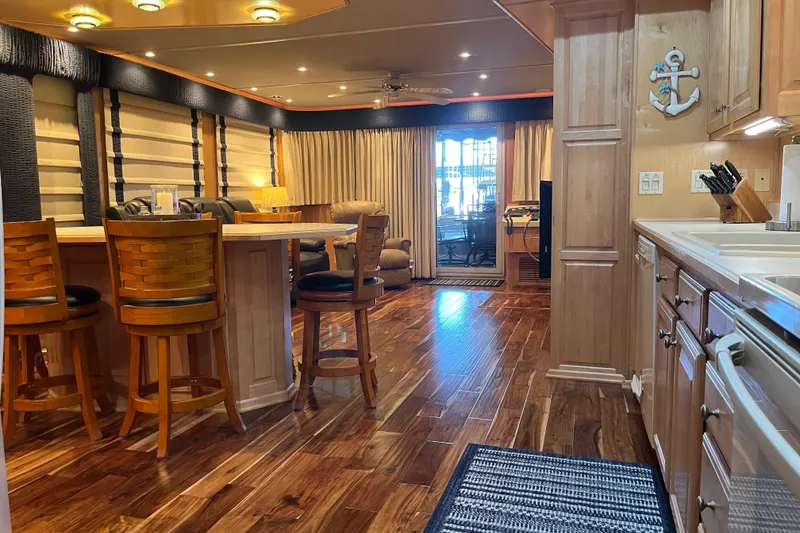 Slide: The Image of Luxurious houseboat interior with wooden flooring, bar stools, and nautical decor, Sharpe 75 model, 2001. - 13