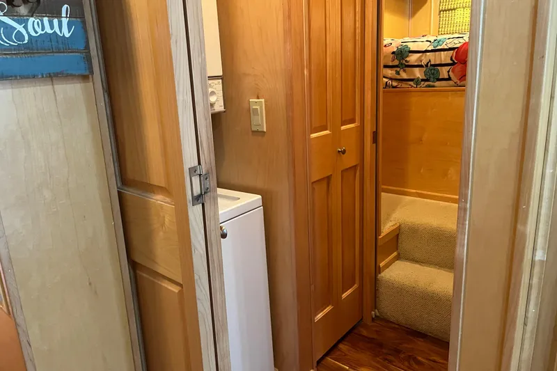 Slide: The Image of Compact laundry area in 2001 Sharpe 75 houseboat with wooden interior and cozy stairs. - 20