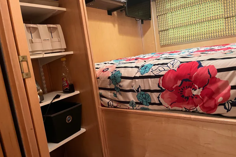 Slide: The Image of Cozy bedroom in 2001 Sharpe 75 houseboat with floral bedding and storage shelves. - 27