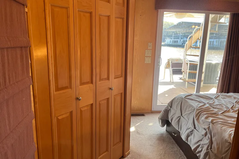 Slide: The Image of Bedroom with wooden closet, sliding glass door, and outdoor view on a 2001 Sharpe 75. - 30