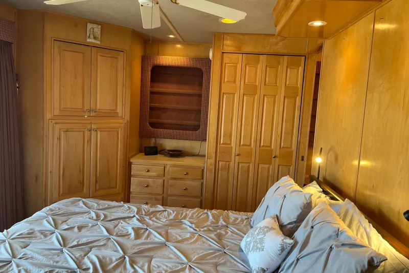 Slide: The Image of Cozy bedroom in 2001 Sharpe 75 houseboat with wooden cabinets and ceiling fan. - 31