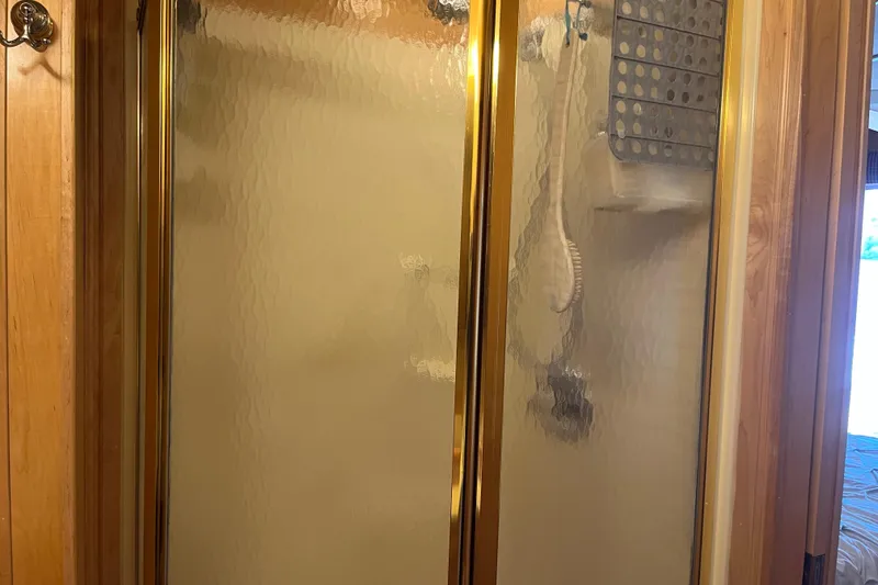 Slide: The Image of Glass shower door with gold trim in a bathroom, Sharpe model 75, 2001. - 34