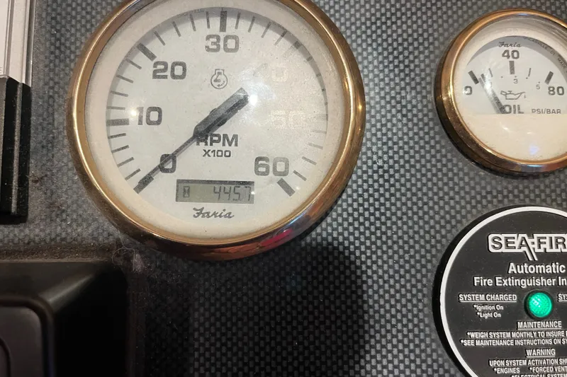 Slide: The Image of Close-up of Sharpe 75 dashboard gauges, including RPM and oil pressure, with fire extinguisher label. - 40