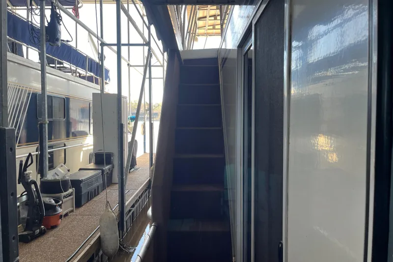 Slide: The Image of Narrow passageway on a 2001 Sharpe 75 houseboat with stairs and docked surroundings. - 44