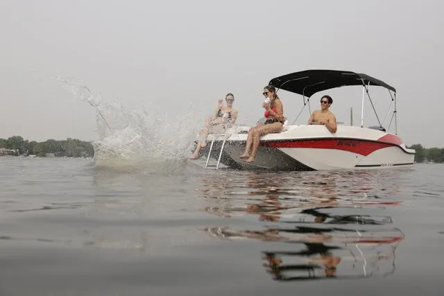 Slide: The Image of 2025 Starcraft SVX211 boat with people enjoying water activities on a lake. - 1