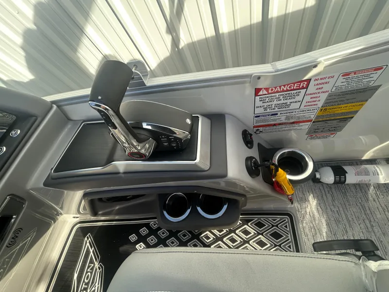 Slide: The Image of 2025 Bennington Q 27 boat control panel with throttle and safety warnings. - 9