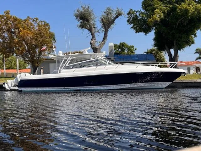 Slide: The Image of 2016 Intrepid 430 Sport Yacht docked by a tree-lined waterfront. - 1