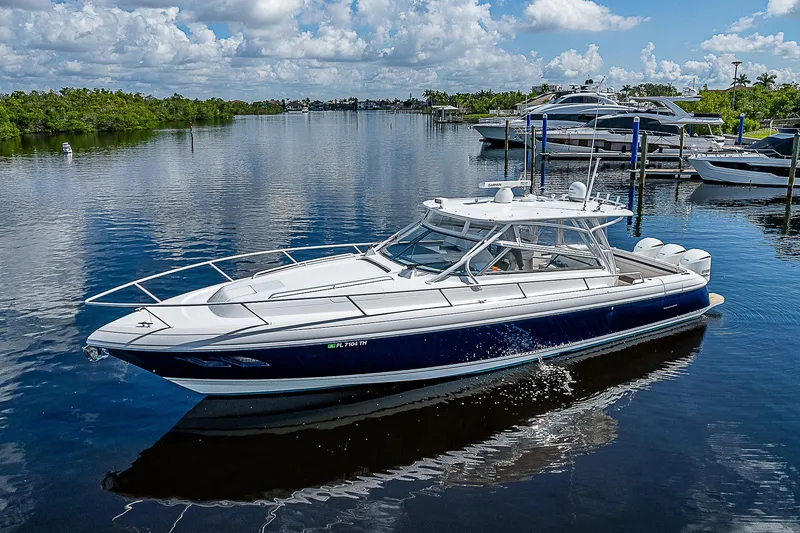 Slide: The Image of 2016 Intrepid 430 Sport Yacht cruising on a serene waterway under a blue sky. - 10