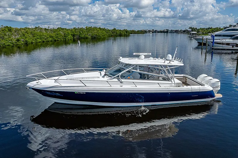 Slide: The Image of 2016 Intrepid 430 Sport Yacht on calm water, showcasing sleek design and luxury features. - 11