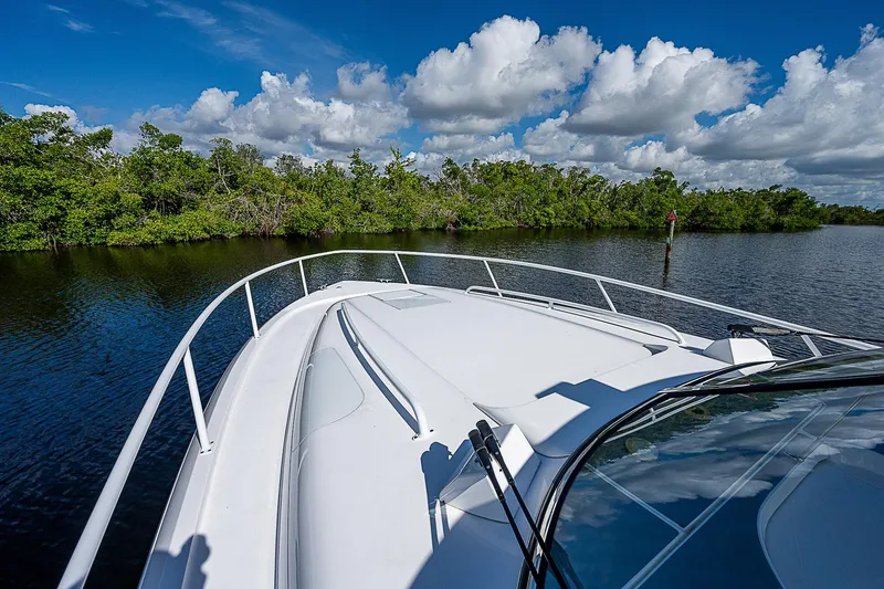 Slide: The Image of Intrepid 430 Sport Yacht 2016 cruising on a serene waterway under a blue sky. - 17