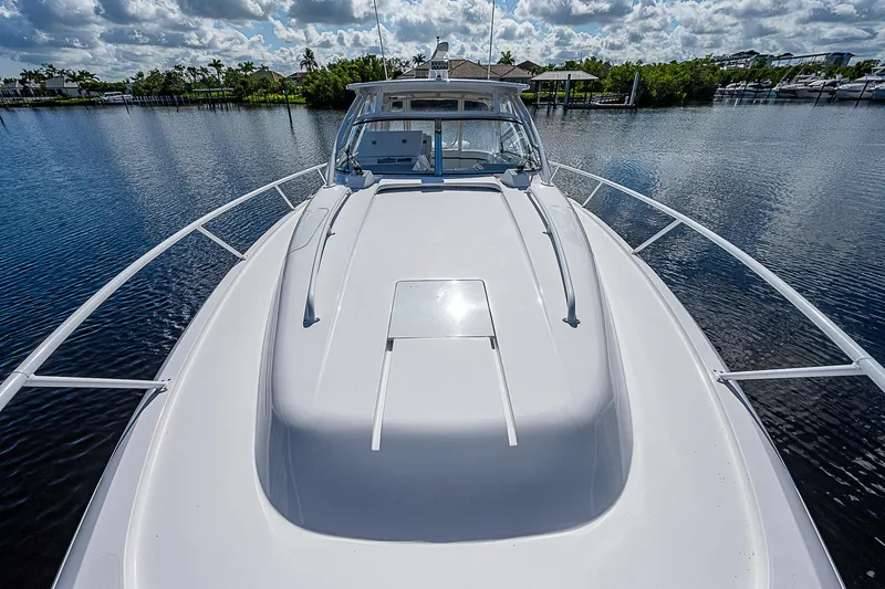 Slide: The Image of 2016 Intrepid 430 Sport Yacht on calm water, showcasing sleek design and spacious deck. - 19