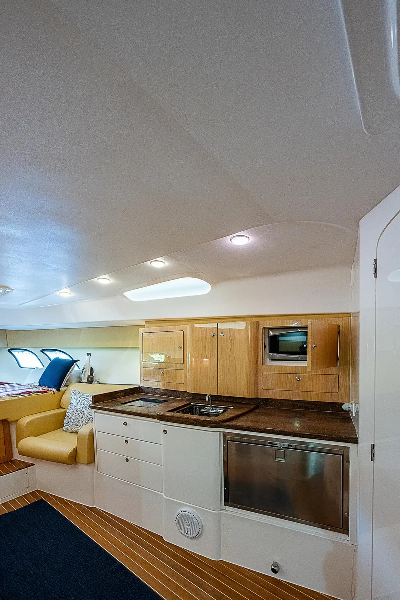 Slide: The Image of 2016 Intrepid 430 Sport Yacht interior with modern kitchen and cozy seating area. - 25