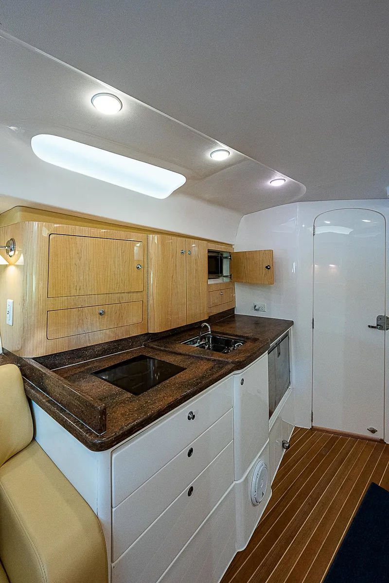 Slide: The Image of Interior of 2016 Intrepid 430 Sport Yacht with modern kitchen and wooden cabinetry. - 26