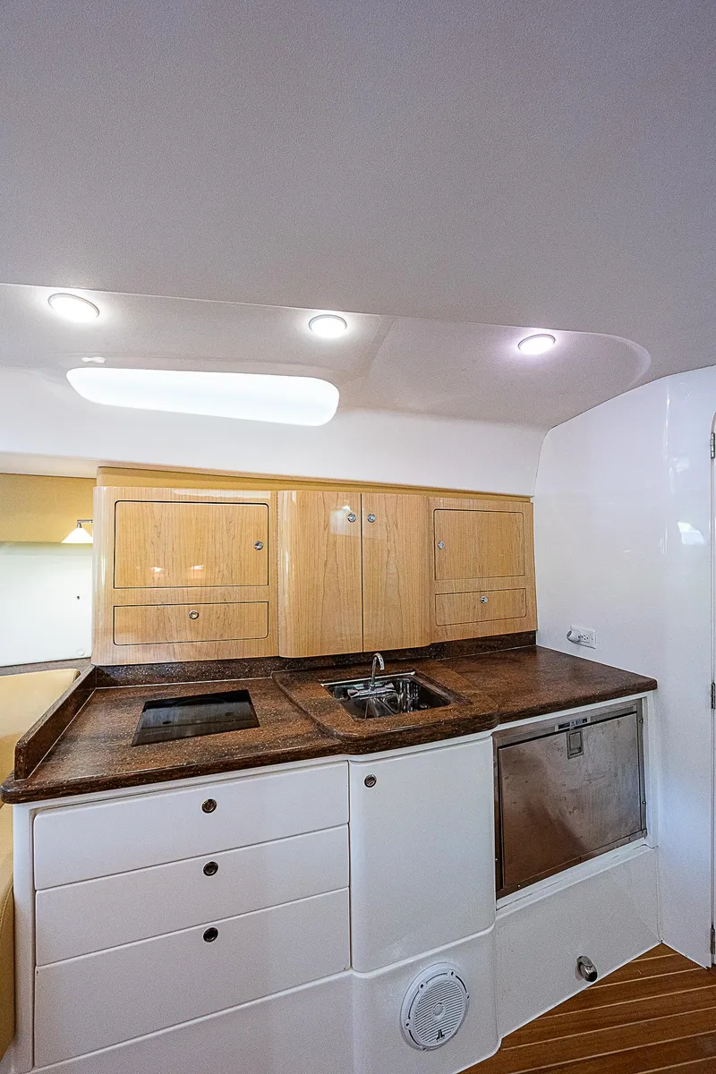 Slide: The Image of 2016 Intrepid 430 Sport Yacht interior kitchen with wooden cabinets and modern appliances. - 27