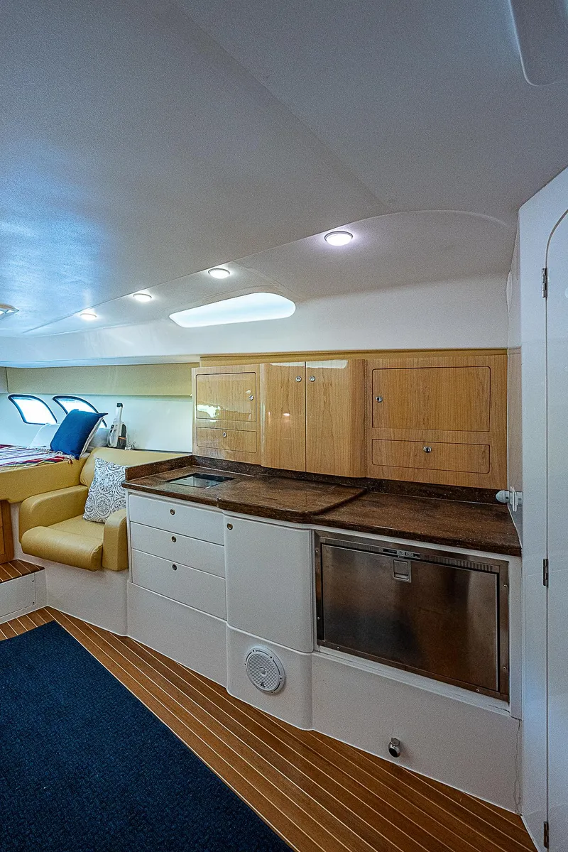 Slide: The Image of Interior of 2016 Intrepid 430 Sport Yacht with kitchenette and seating area. - 28