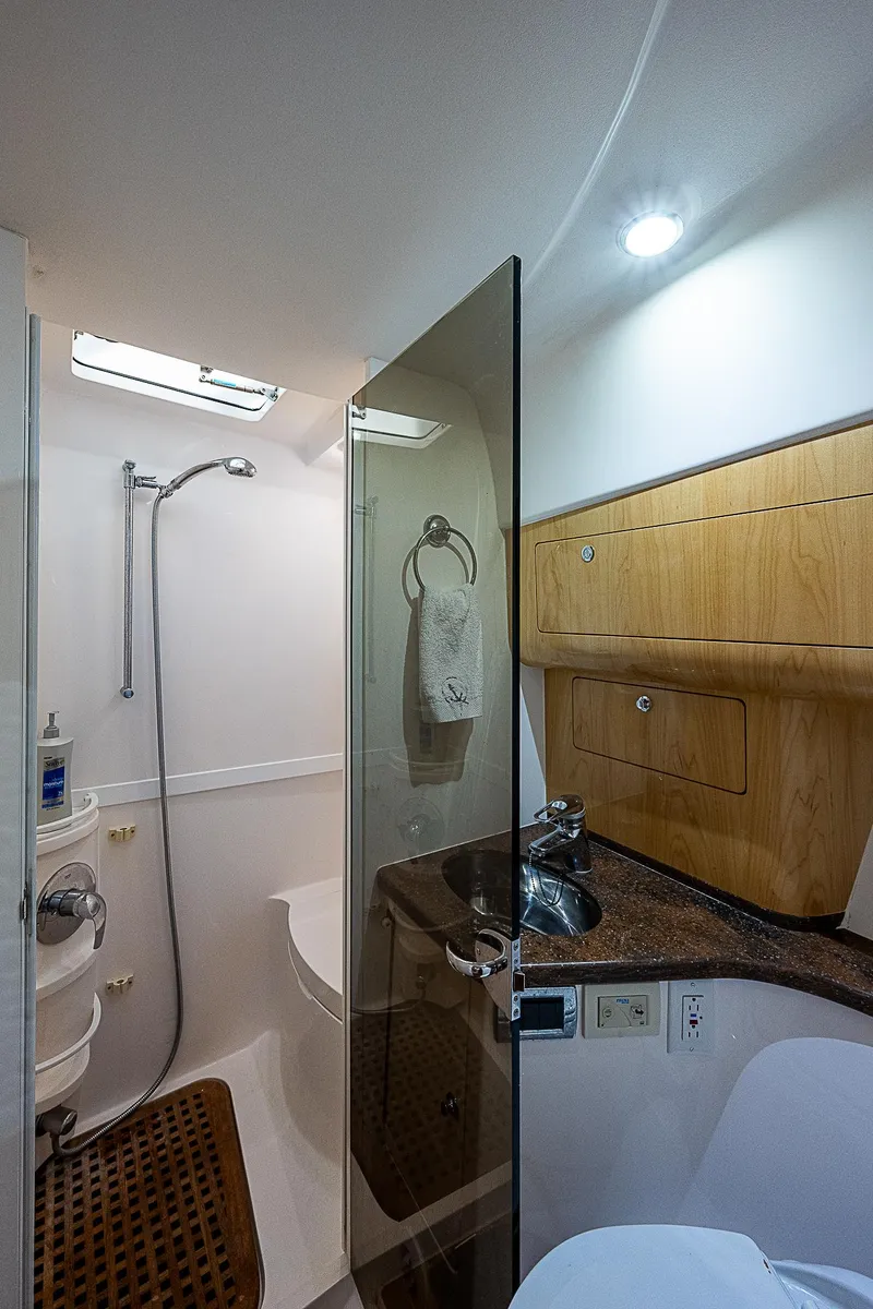 Slide: The Image of 2016 Intrepid 430 Sport Yacht bathroom with modern fixtures and wooden cabinetry. - 30