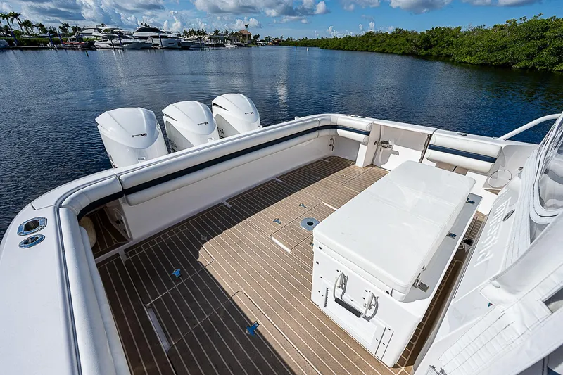 Slide: The Image of 2016 Intrepid 430 Sport Yacht deck with triple outboard motors on calm water. - 34