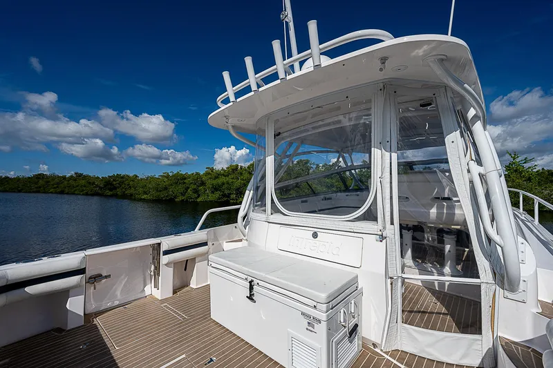 Slide: The Image of 2016 Intrepid 430 Sport Yacht on calm water, showcasing sleek design and spacious deck. - 39