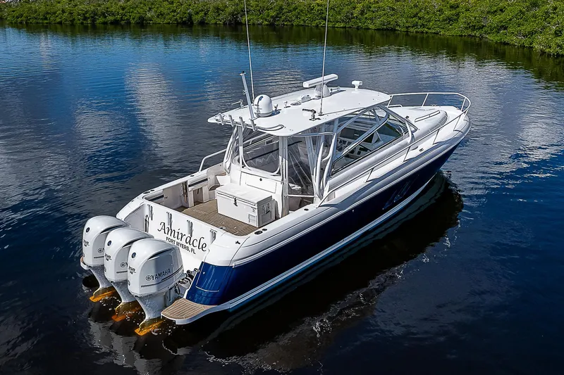 Slide: The Image of 2016 Intrepid 430 Sport Yacht on calm water, featuring triple outboard engines. - 4
