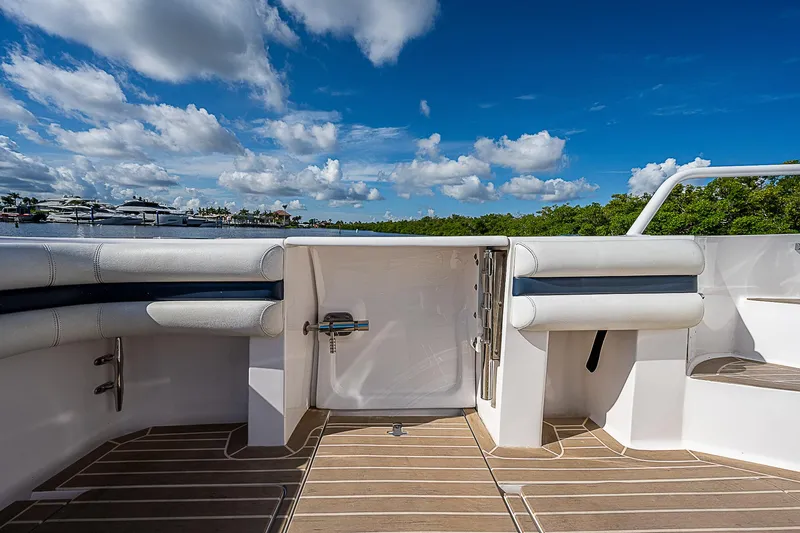 Slide: The Image of 2016 Intrepid 430 Sport Yacht deck with seating, under a clear blue sky. - 40