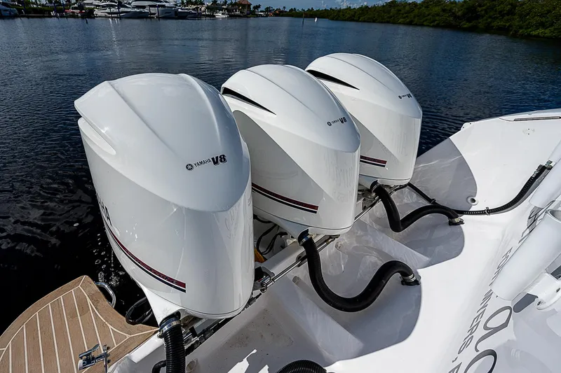 Slide: The Image of Triple outboard engines on a 2016 Intrepid 430 Sport Yacht, docked on calm water. - 43